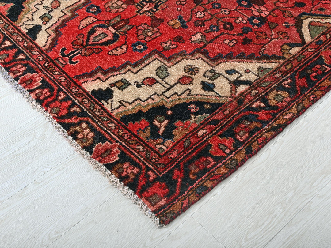 a red and black oriental rug on a white floor