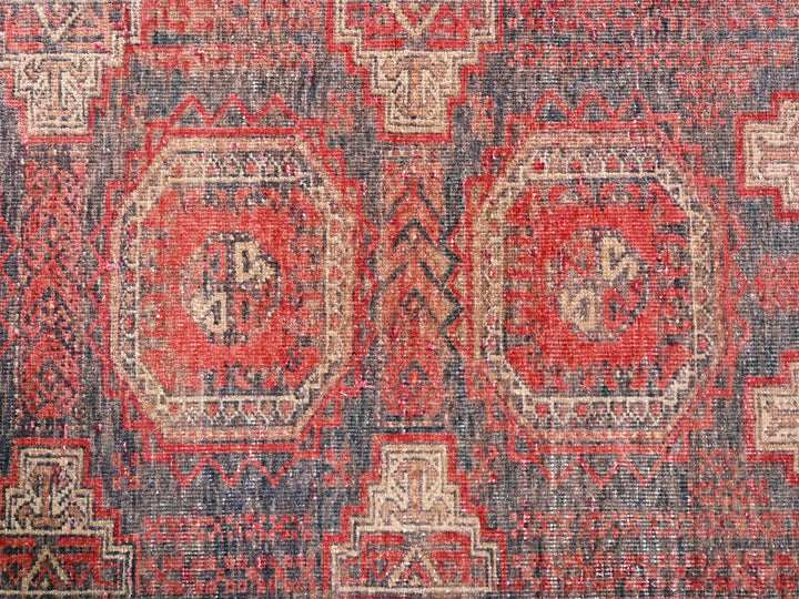 a red and blue rug with an intricate design