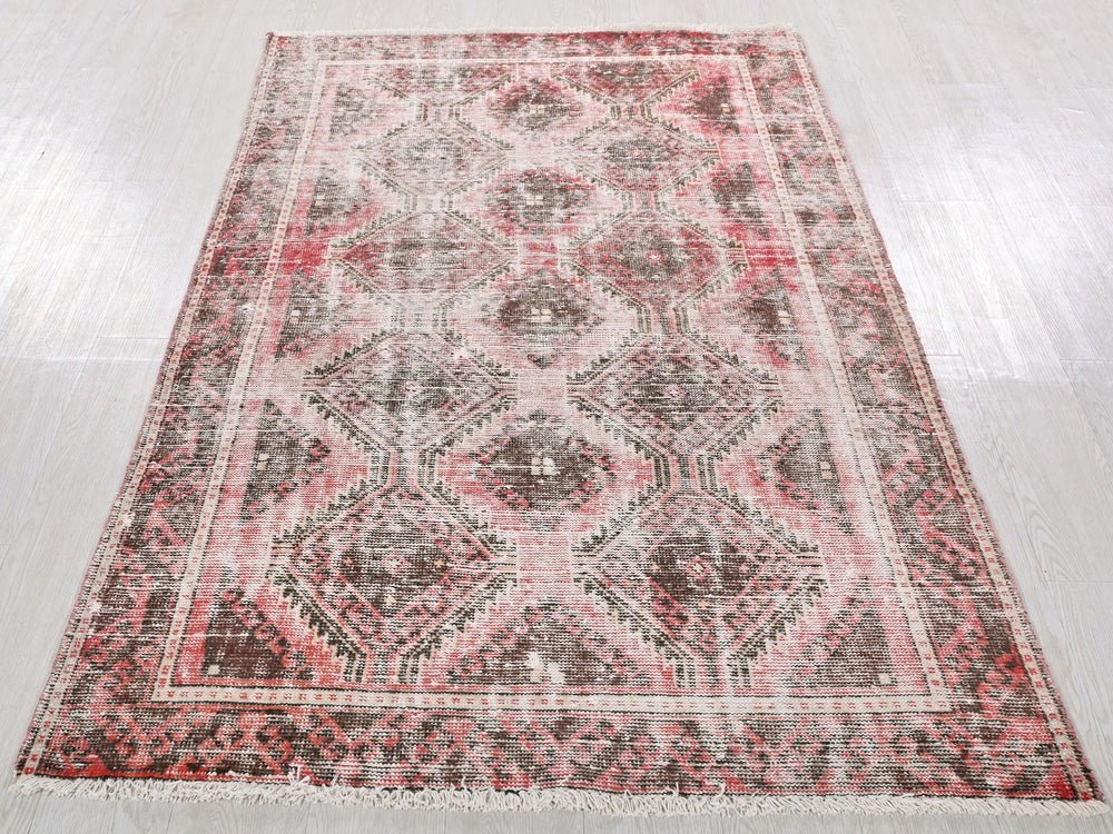 a red and black rug on a white floor