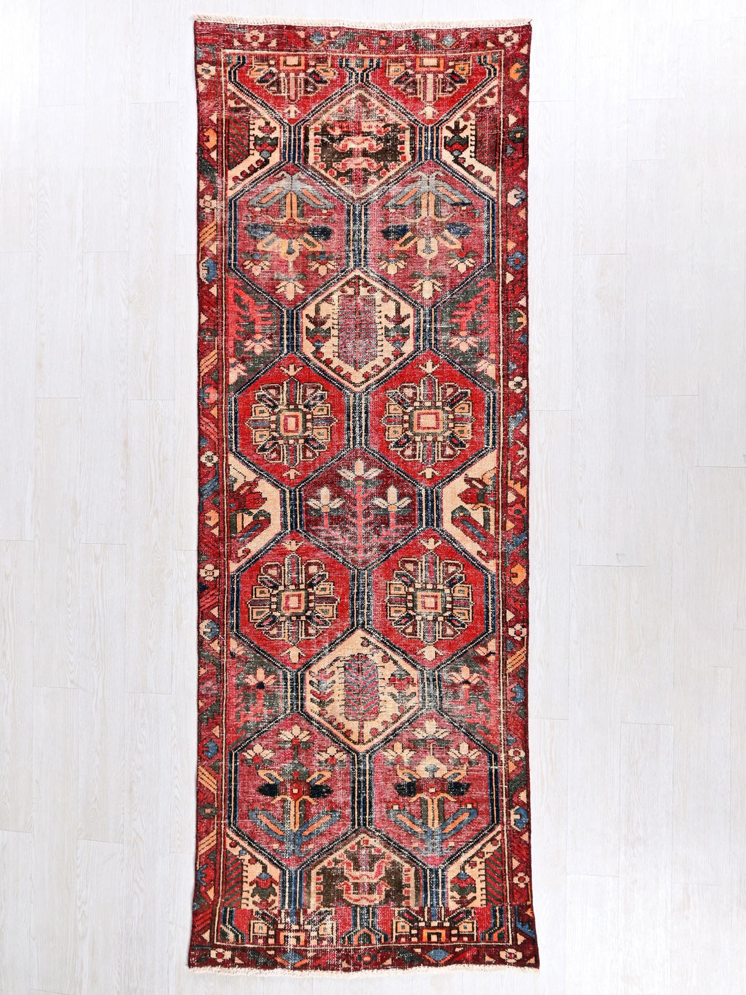 a red rug hanging on a white wall