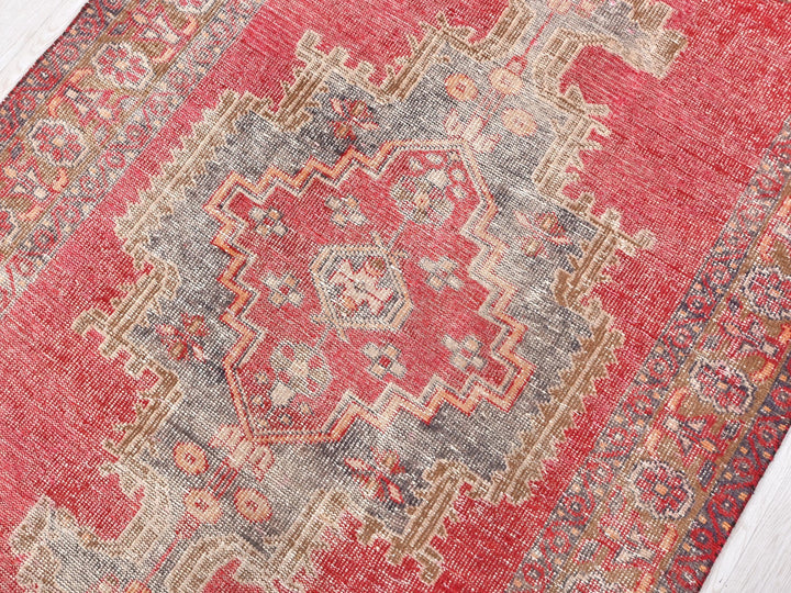 a red rug on a white wooden floor