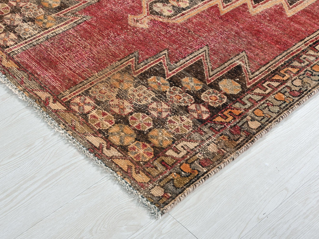 a red and black oriental rug on a white floor