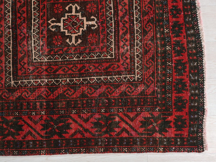a red and black rug on a white floor