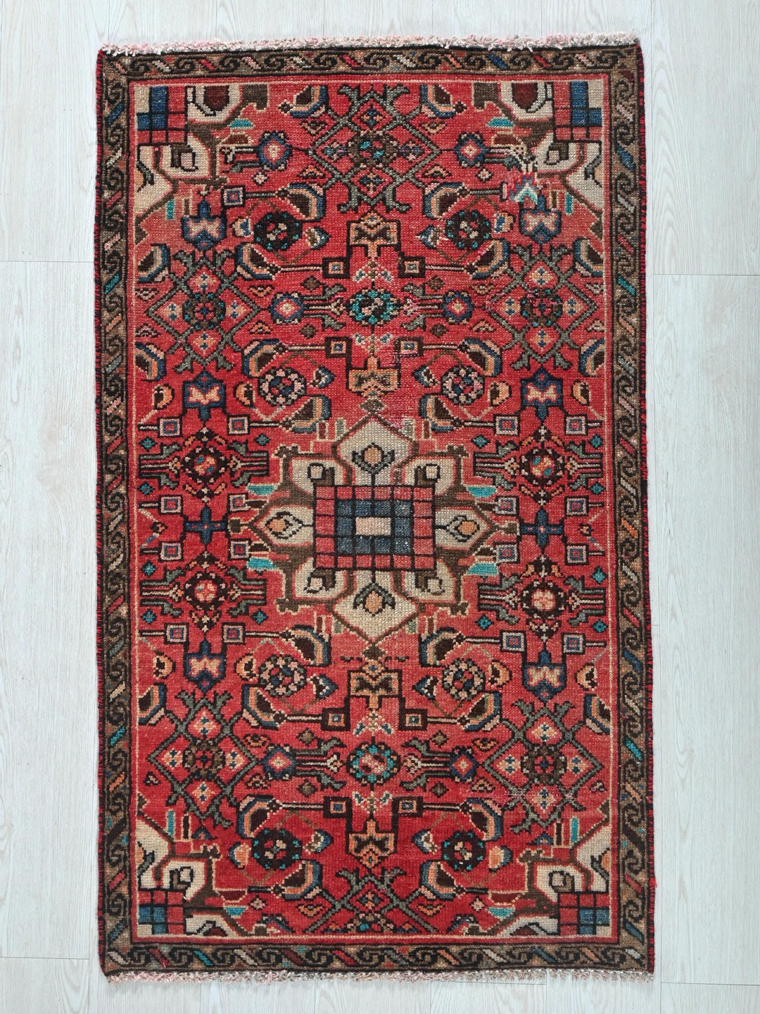 a red rug on a white wooden floor