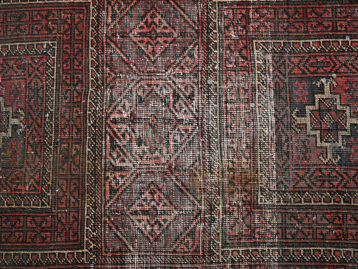 a red and black rug with a design on it