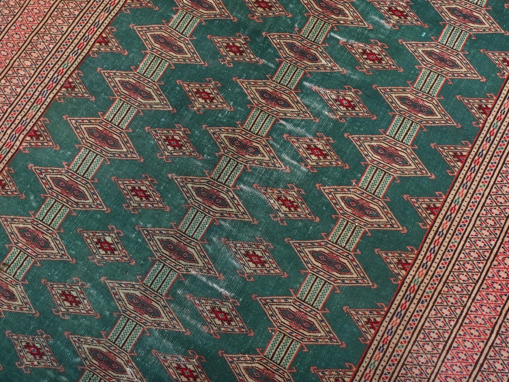 a green rug with red and blue designs on it