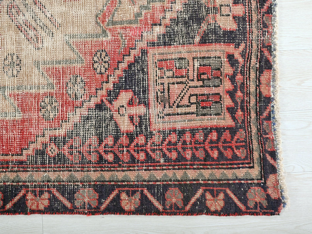 a red and black rug on a white surface