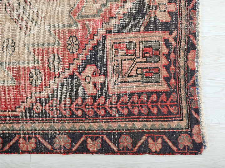 a red and black rug on a white surface