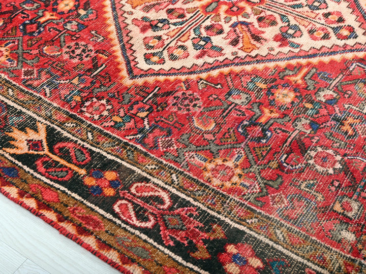 a red oriental rug with an intricate design