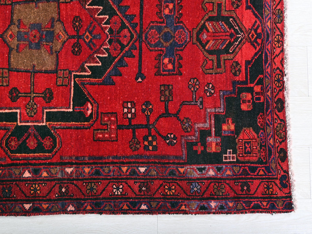 a red rug with black and brown designs on it