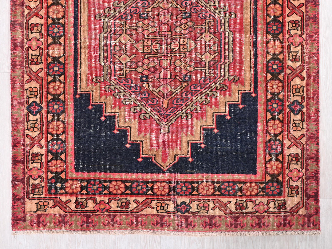 a red and blue rug with an intricate design
