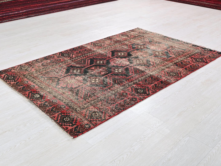 a red and black rug on a white floor