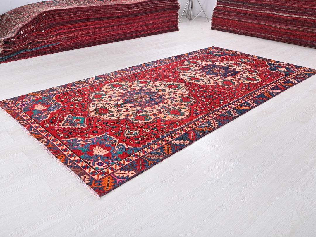 a pile of red rugs sitting on top of a white floor