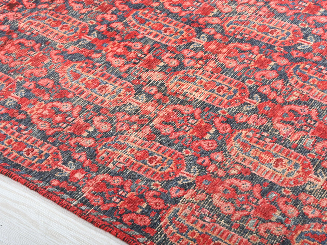 a red and blue rug with a white border
