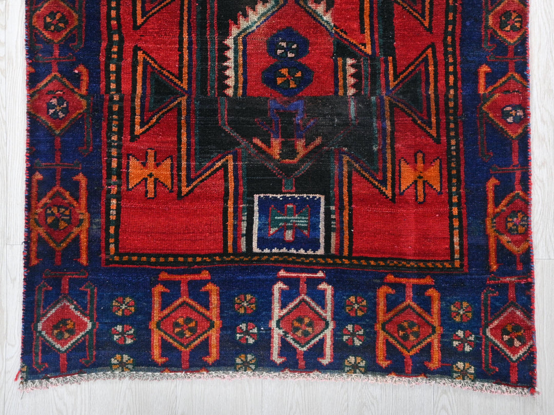 a red and blue rug with a design on it