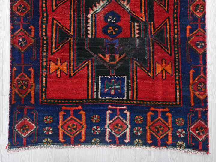 a red and blue rug with a design on it