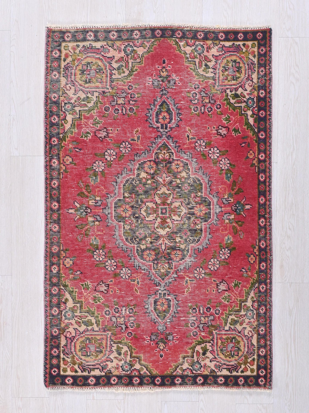 a red rug with a floral design on it