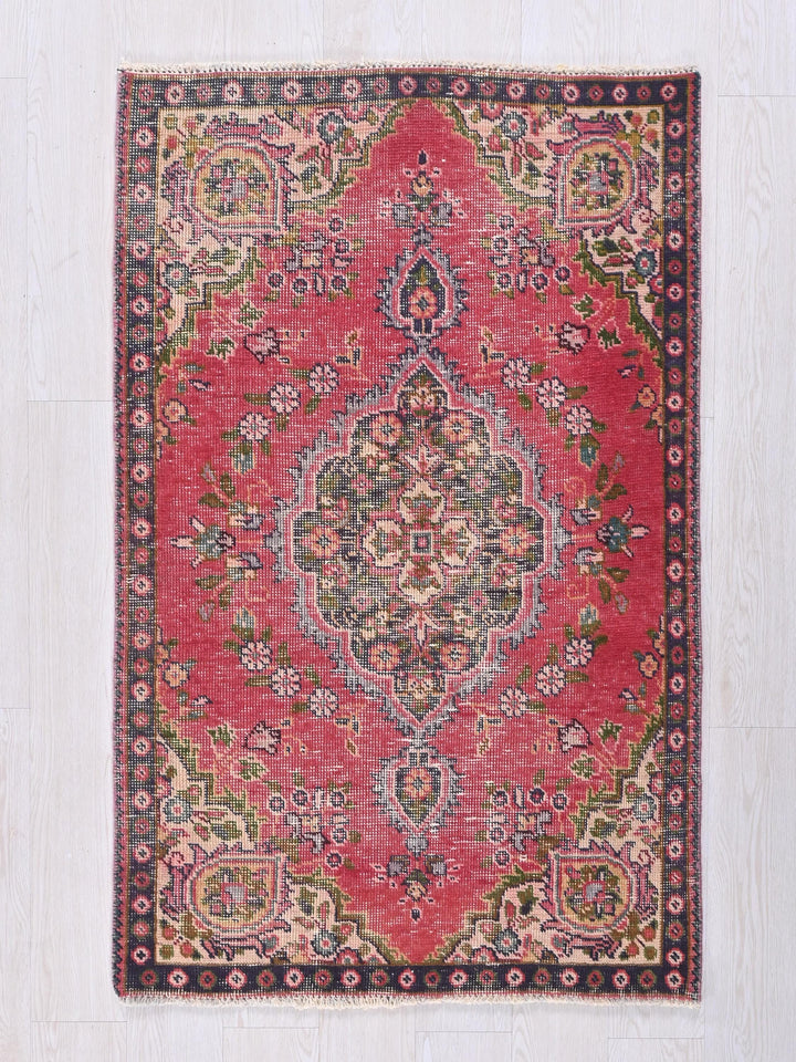 a red rug with a floral design on it
