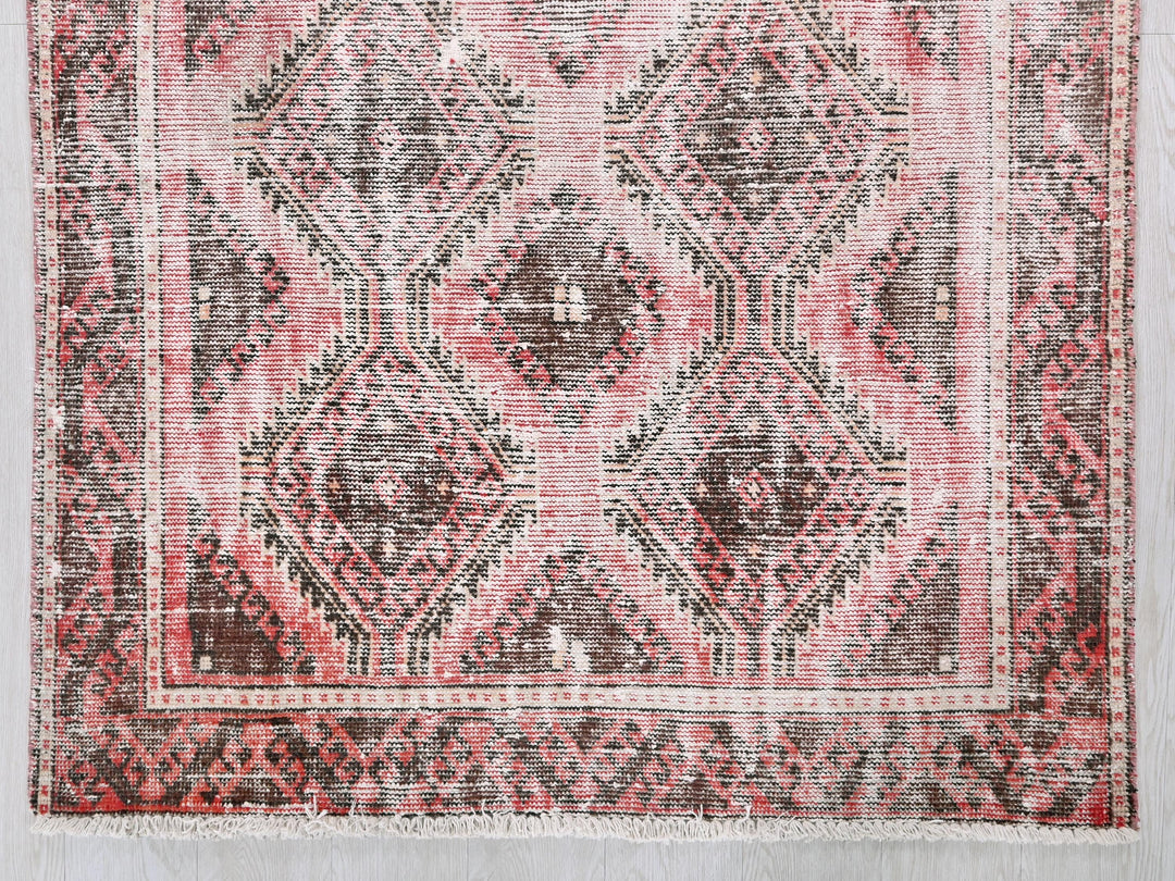 a red and black rug on a white wall