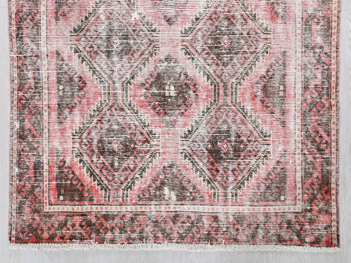 a red and black rug on a white wall