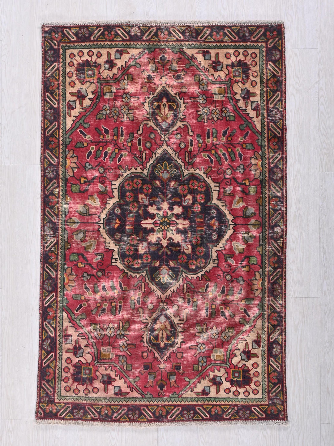 a red rug with a floral design on it