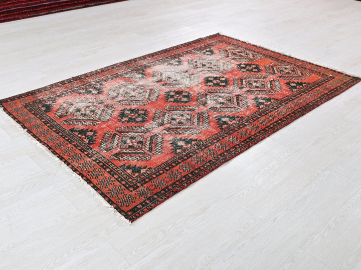 a red and black rug on a white floor