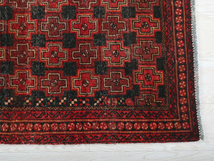 a red and black rug on a white floor