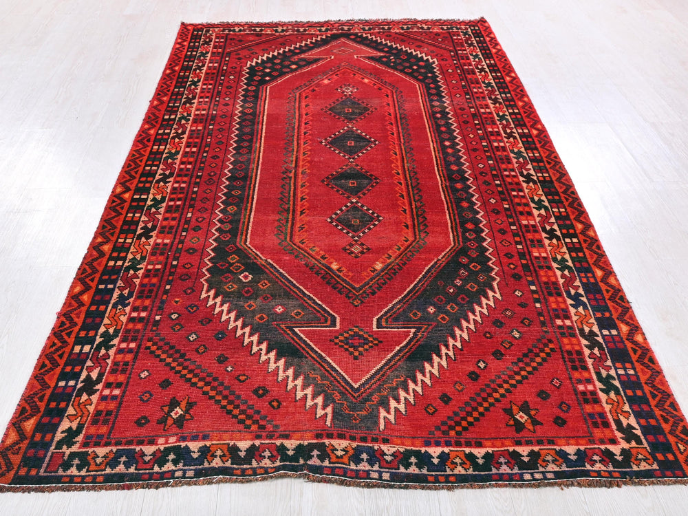 a red rug with a design on the middle of it