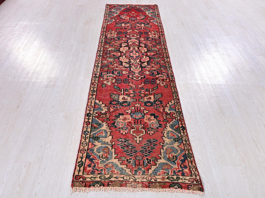 a long red rug on a white floor