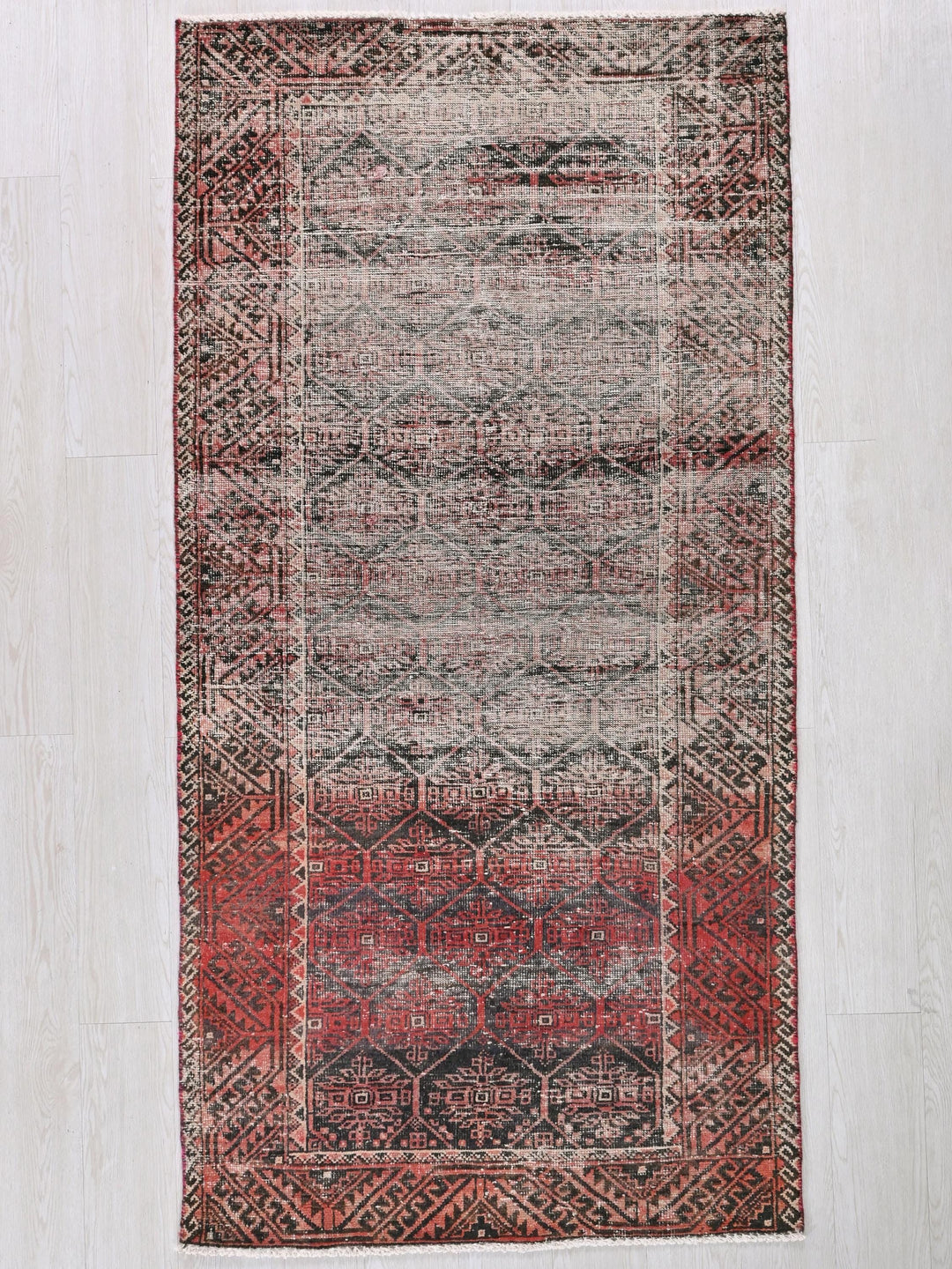 a red and black rug on a white floor