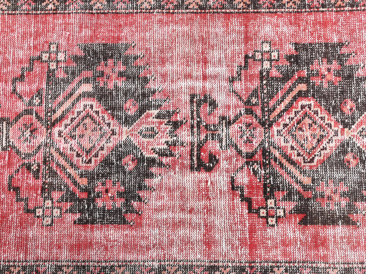 a close up of a red rug with black and white designs