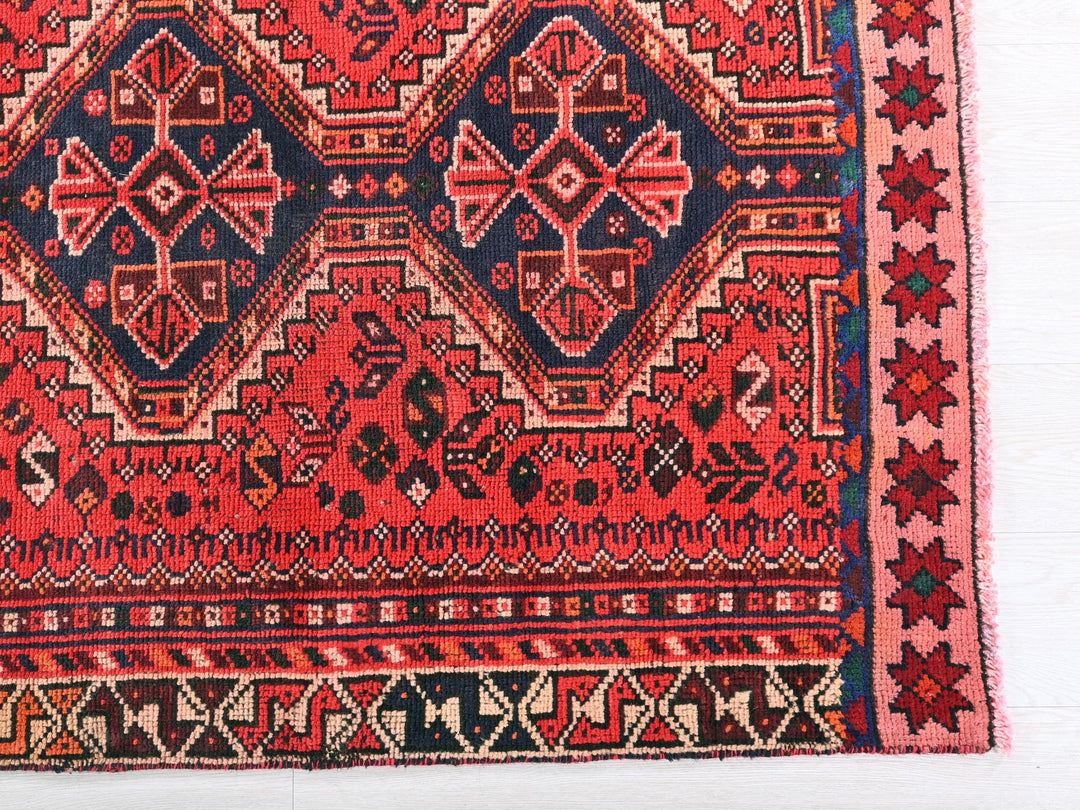 a red rug with a blue and red design on it