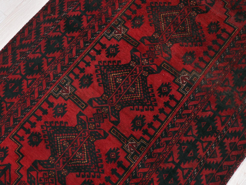 a red and black rug on a white floor