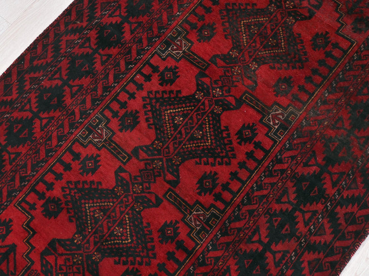 a red and black rug on a white floor