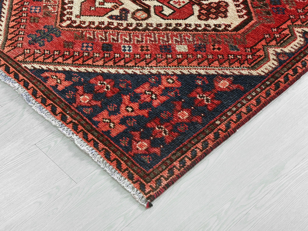 a red and blue rug on a white floor