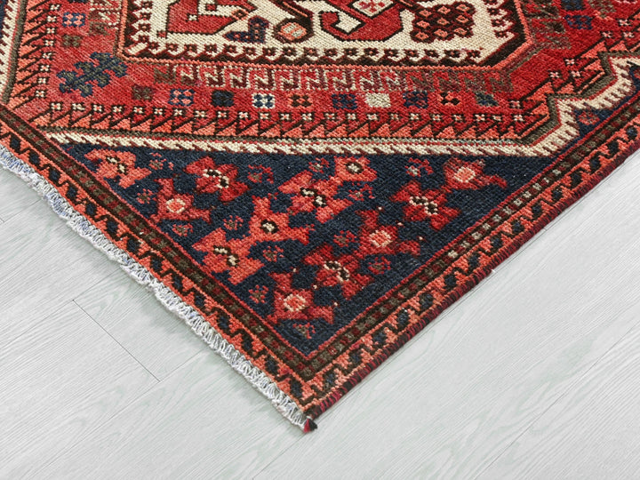 a red and blue rug on a white floor
