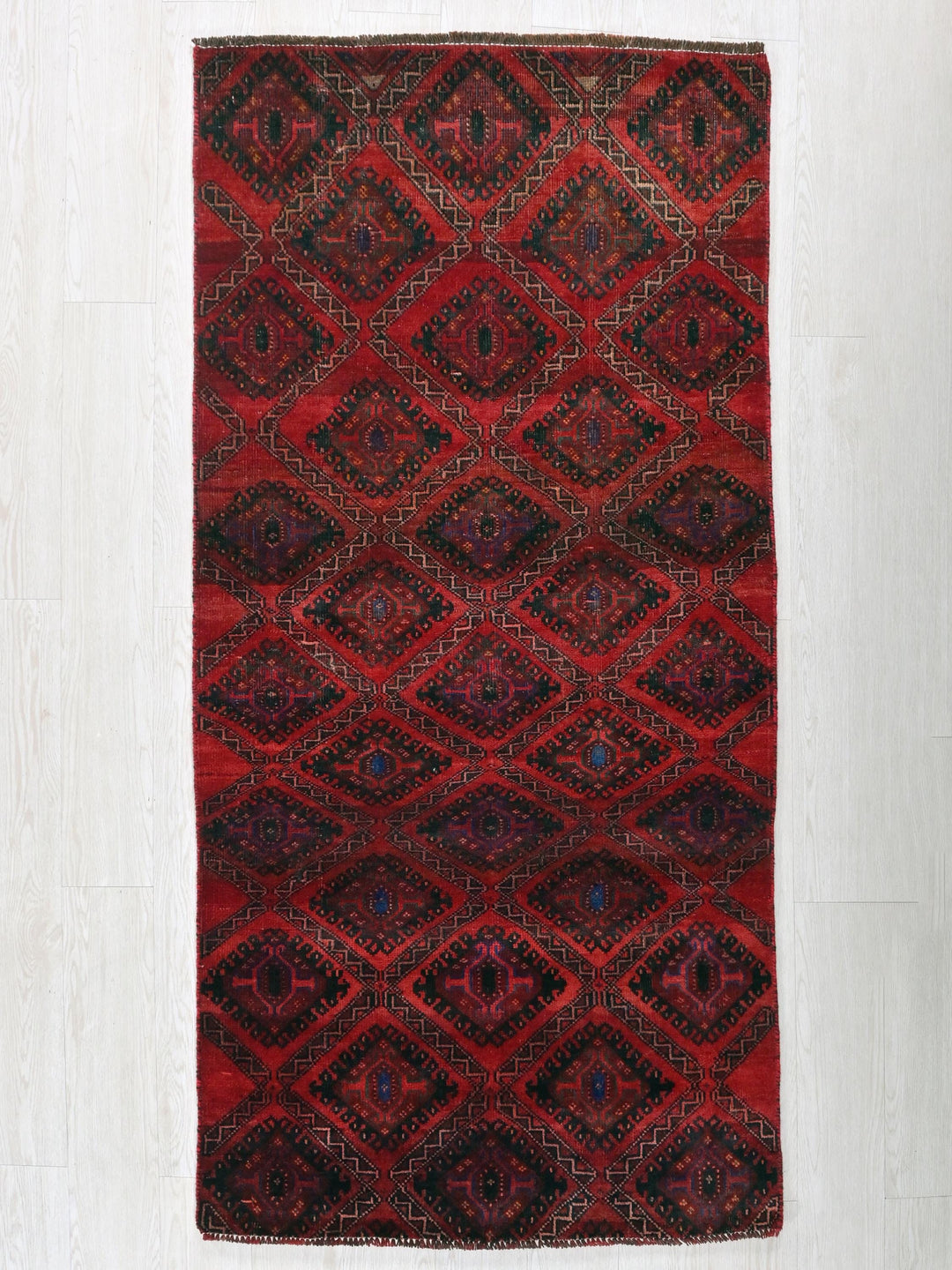a red and black rug on a white floor
