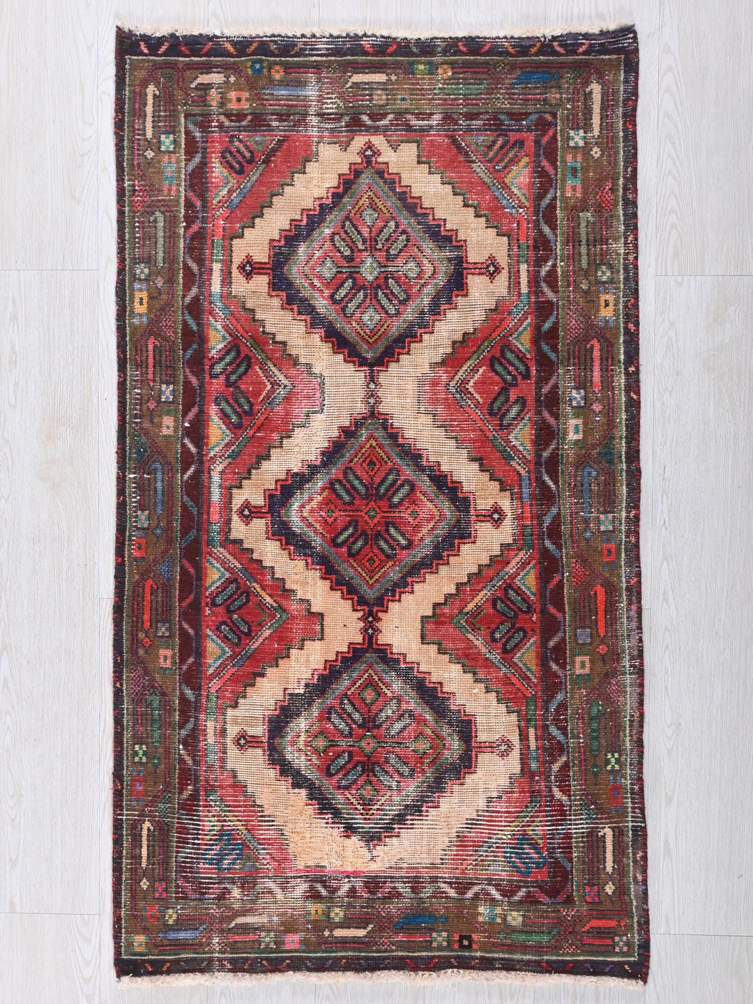 a red and blue rug on a white floor