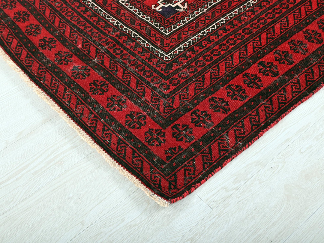 a red and black rug on a white floor