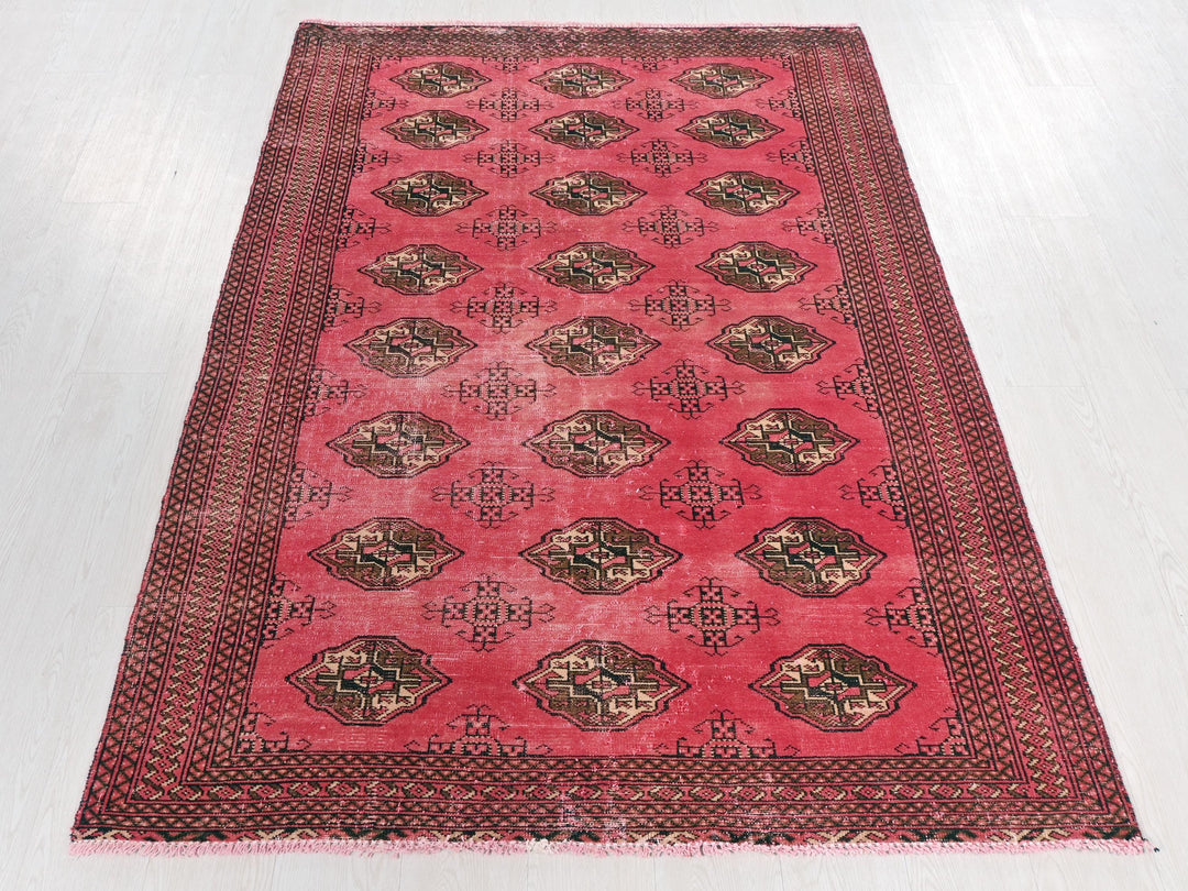 a red rug with a design on the middle of it