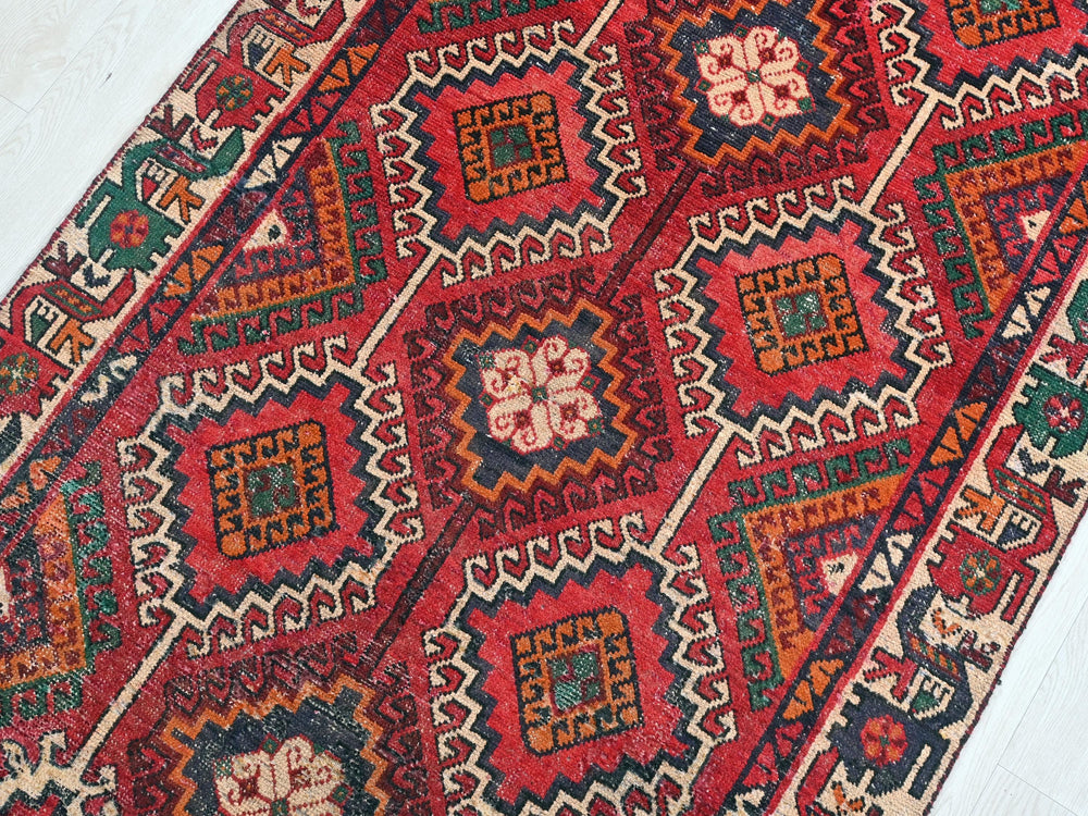 a red rug with a pattern on the middle of it