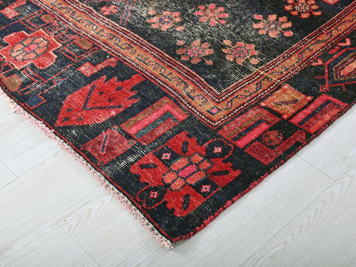 a red and black oriental rug on a white floor