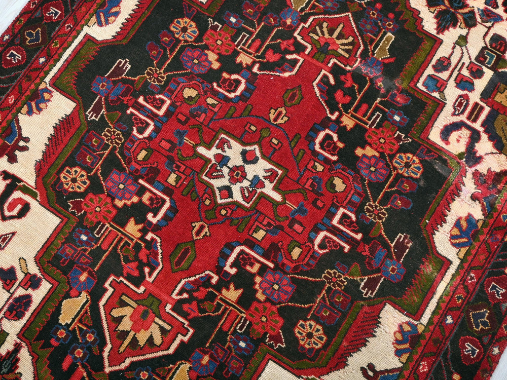 a red and black oriental rug on a white floor