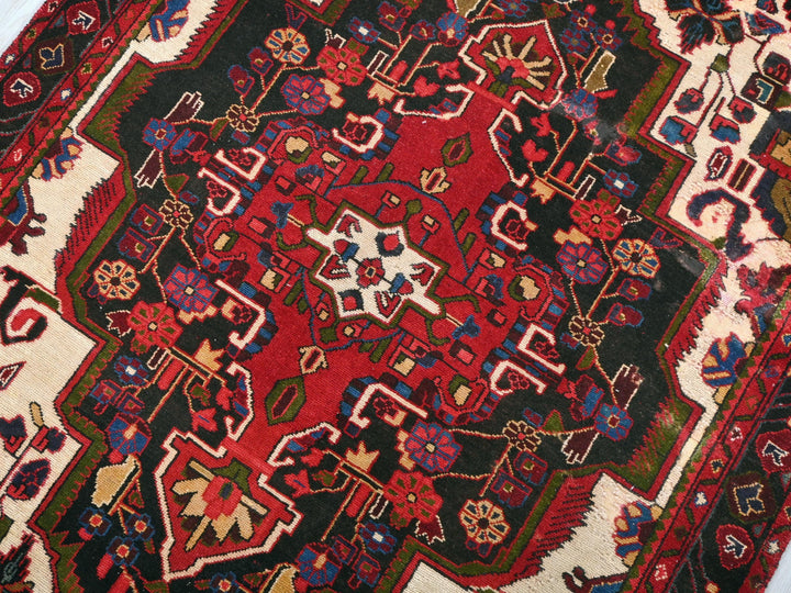 a red and black oriental rug on a white floor