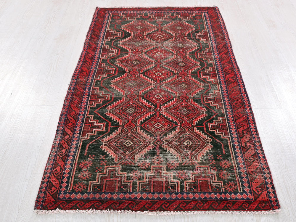 a red and black rug on a white floor