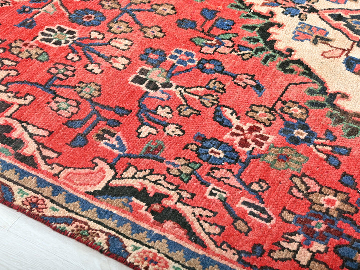 a red rug with a blue and pink design on it