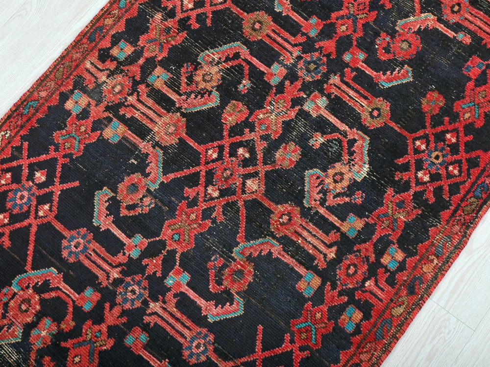 a red and black oriental rug on a white floor