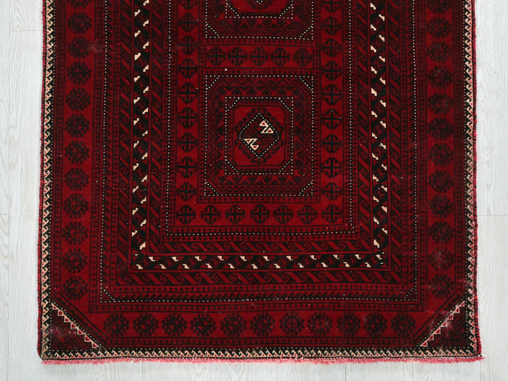 a red and black rug on a white floor
