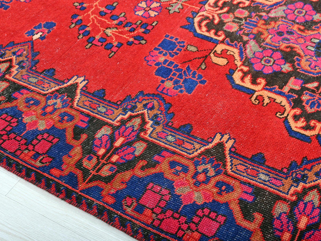 a red rug with blue and pink designs on it