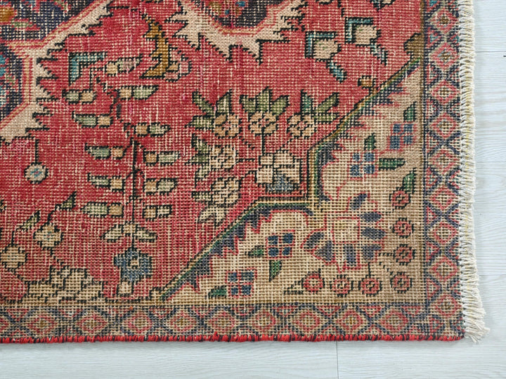 a red rug with a floral design on it